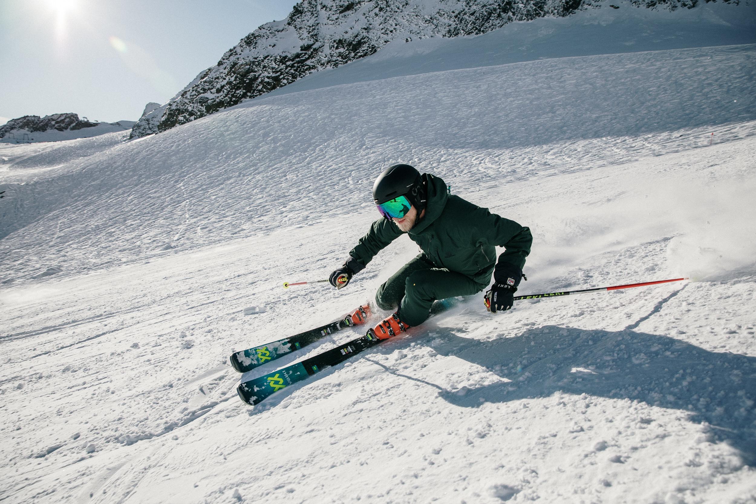Ein Mann fährt Ski durch eine sonnige Schneelandschaft