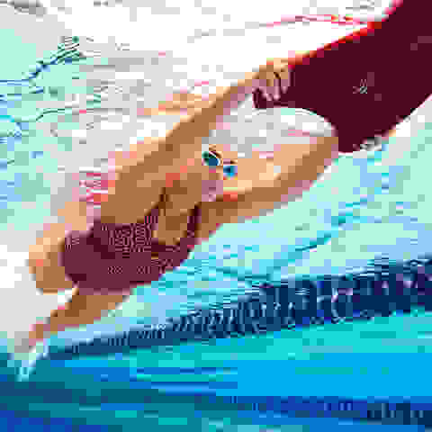 Eine Frau übt Beintechnik beim Schwimmen mit einem Schwimmbrett