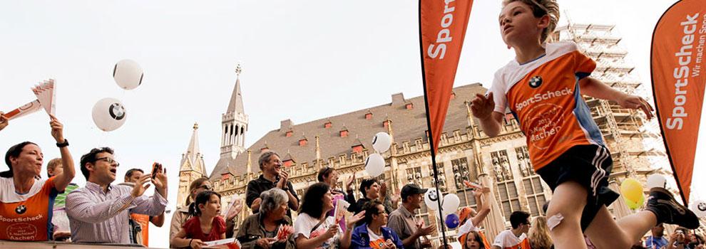 Ein junger Läufer rennt während des Aachener Stadtlauf für Kids an den Fans vorbei.