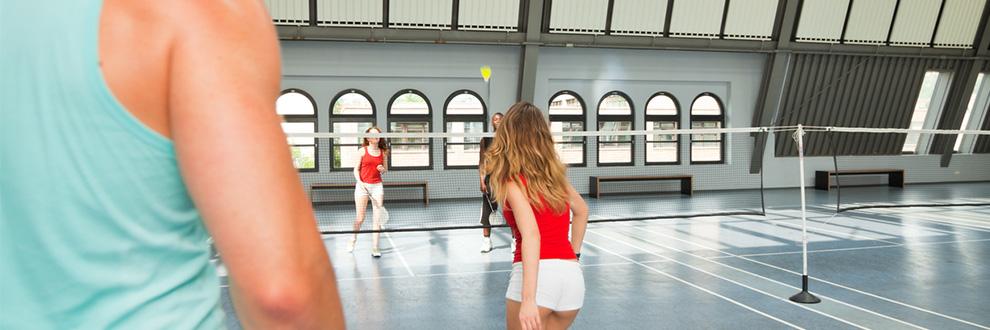 Eine Gruppe von Leuten spielt Badminton in der Halle.