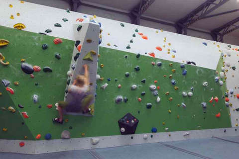 Eine Frau bouldert horizontal eine Kletterwand entlang Fotostrecke Bild 5