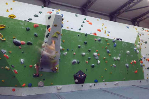 Eine Frau bouldert horizontal eine Kletterwand entlang Fotostrecke Bild 4