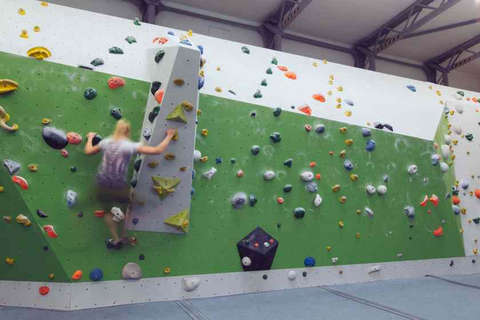 Eine Frau bouldert horizontal eine Kletterwand entlang Fotostrecke Bild 3