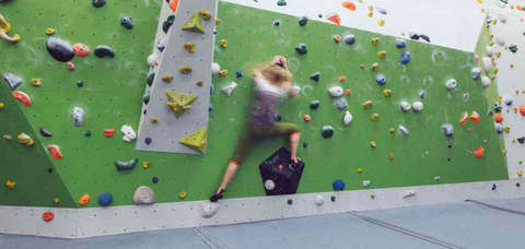 Eine Frau bouldert horizontal eine Kletterwand entlang Fotostrecke Bild 11
