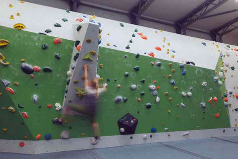 Eine Frau bouldert horizontal eine Kletterwand entlang Fotostrecke Bild 7