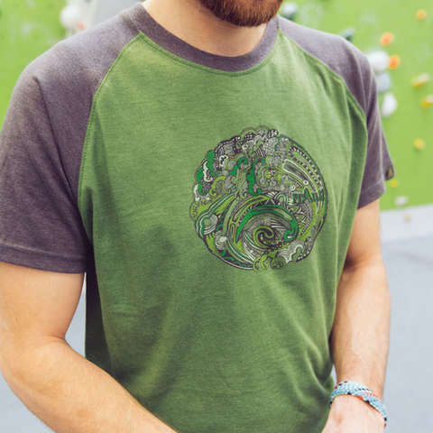 Ein grünes Bouldershirt mit buntem Fantasieaufdruck in der Nahaufnahme. 