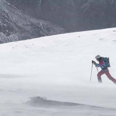 Ein Schneeschuhwanderer durchwandert eine stürmische Schneelandschaft