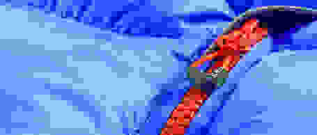Ein roter Zipper von CMP in Nahaufnahme. Dieser ist an einer lila farbener Daunenjacke befestigt.