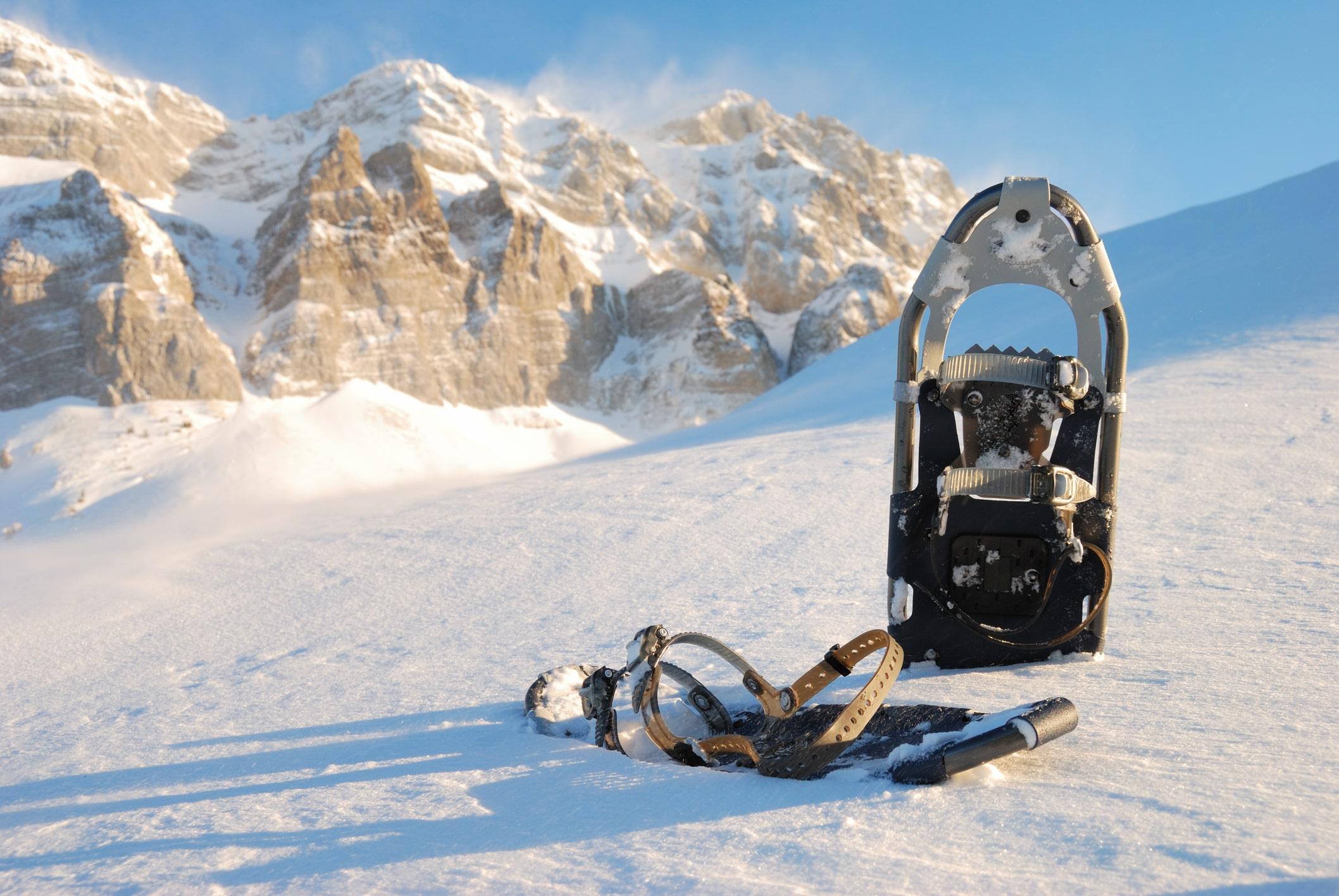 Ein Schneeschuhe steht in einer verschneiten alpinen Landschaft