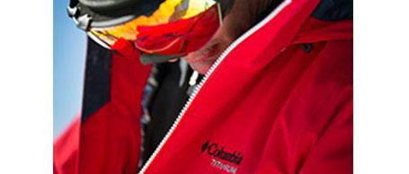 Ein Skifahrer aus der Nähe fotografiert. Er trägt eine Skibrille und eine rote Winterjacke von Columbia Titanium.