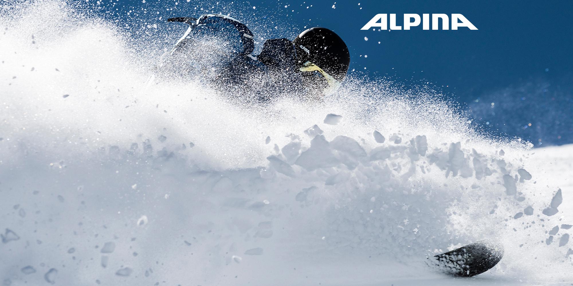 Ein Skifahrer wirbelt beim Fahren eine Menge Schnee auf