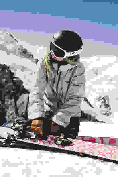 Ein Skifahrer legt der Länge nach an seinem Tourenski ein Skifell an. 