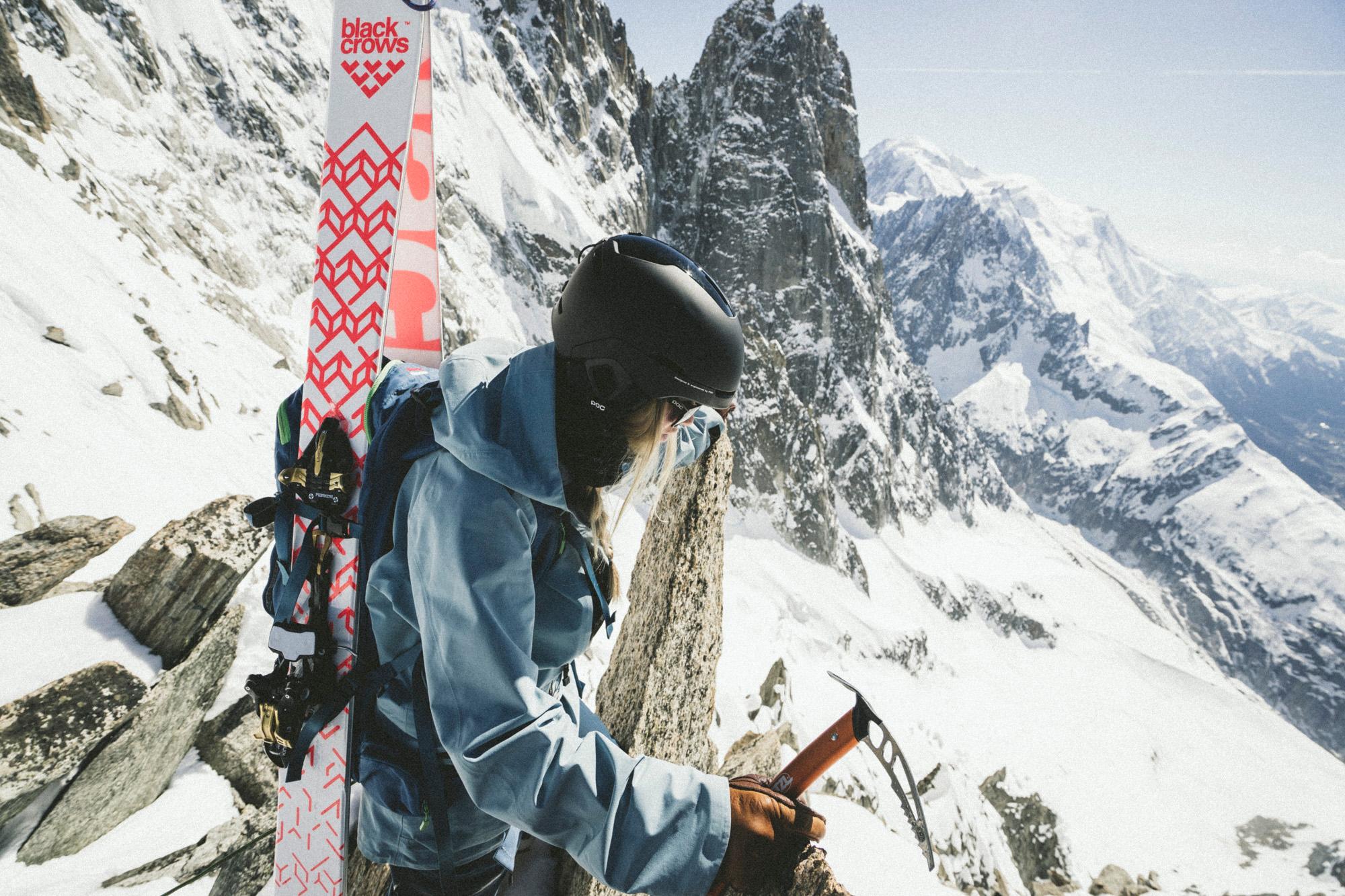 Eine Skitourerin hat ihre Tourenski auf den Rücken geschnallt