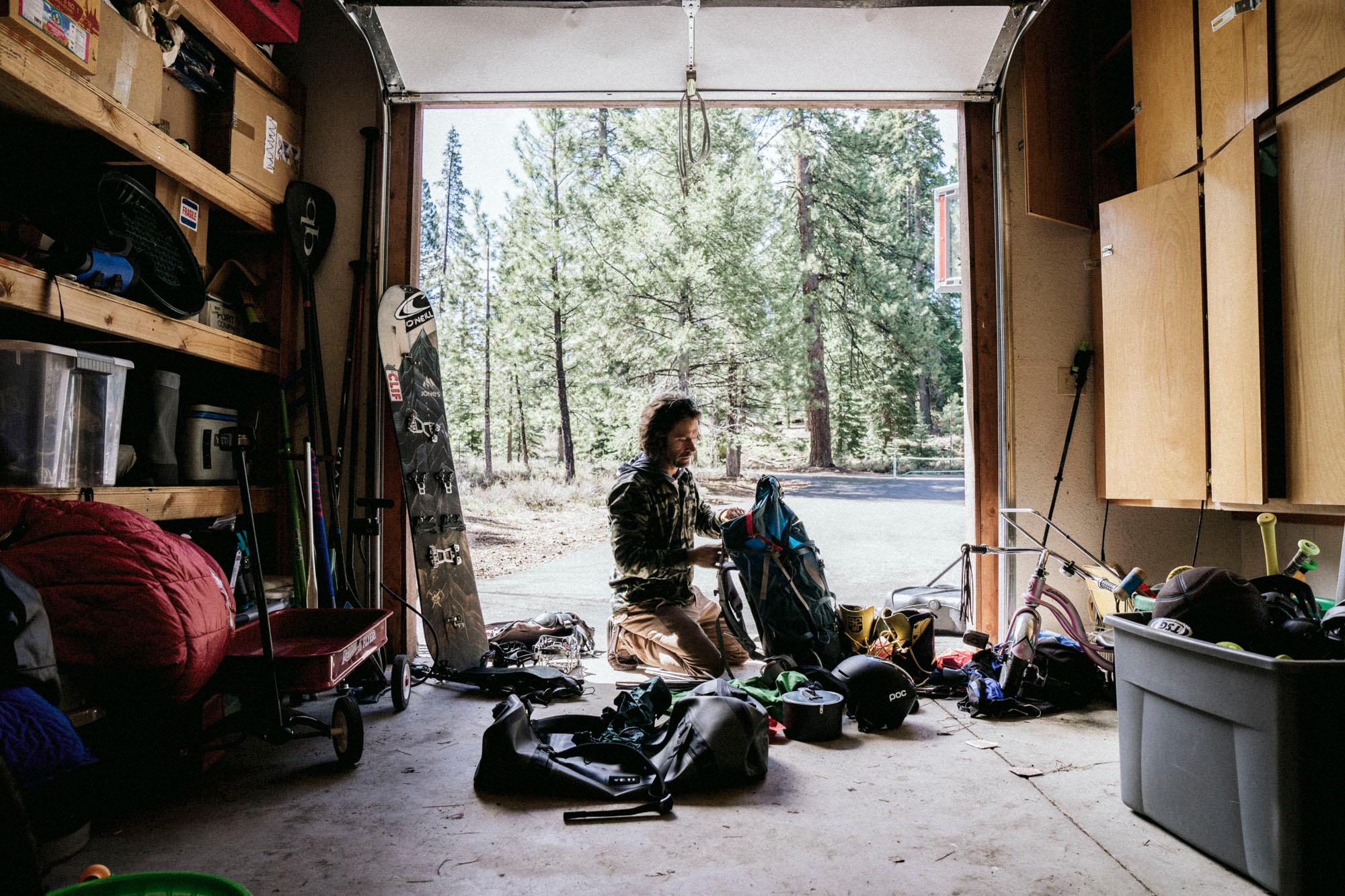 Ein Mann bereitet seine Snowboarding Ausr&uuml;stung in seiner Garage vor