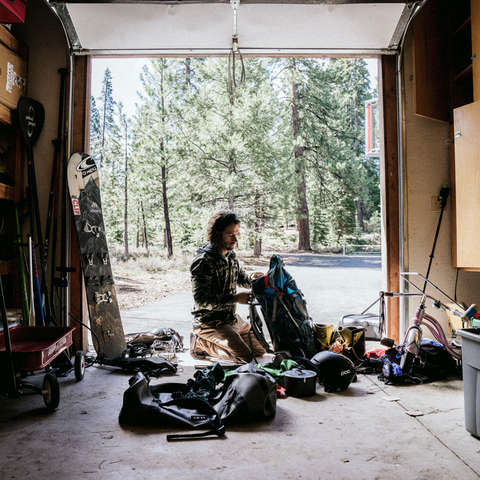Ein Mann bereitet seine Snowboarding Ausrüstung in seiner Garage vor