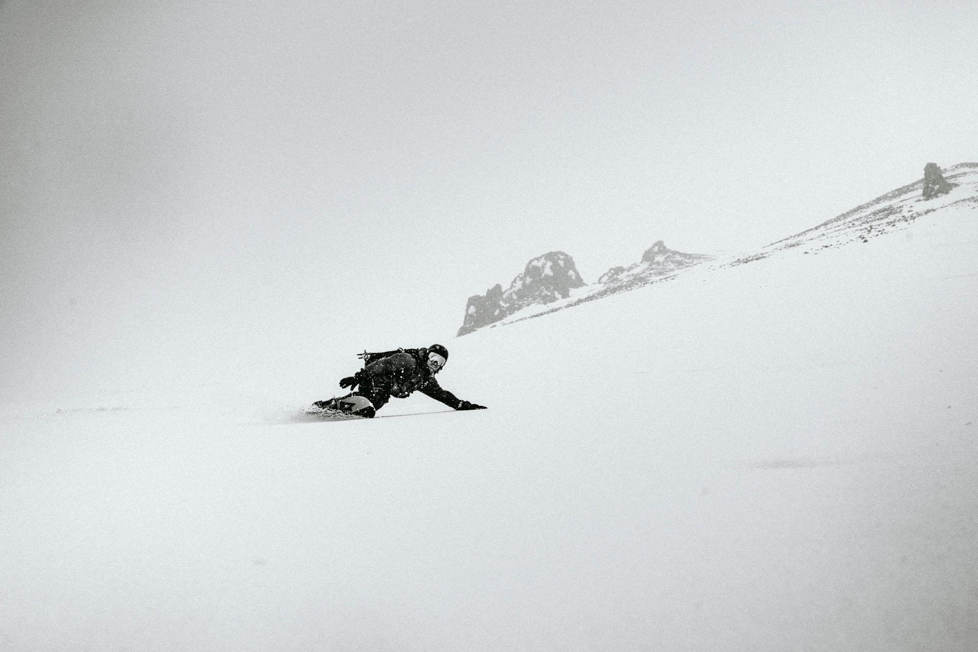 Ein Snowboarder f&auml;hrt abseits der Piste einen unber&uuml;hrten Tiefschneehang hinab.