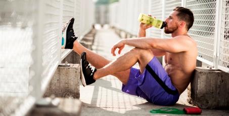 Ein Mann sitzt auf dem Boden und erholt sich nach dem Training.