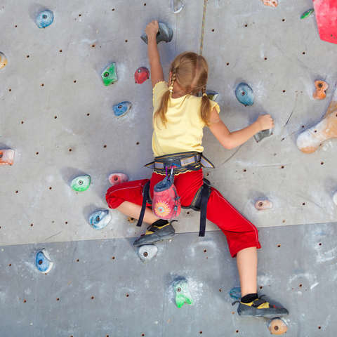 Ein Mädchen klettert Toprope in der Halle