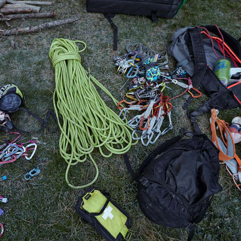 Diverse Kletterausrüstung auf dem Fußboden ausgebreitet.