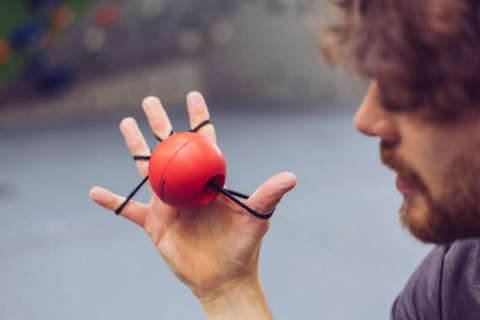 Ein Mann trainiert mit einem Fingerball seine Finger und wärmt diese auf.