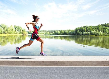 Um die Vertikalbewegung zu analysieren, läuft eine Frau einen Pfad am Wasser entlang.
