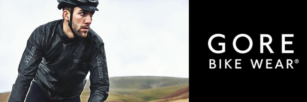 Ein Radfahrer f&auml;hrt durch die Natur mit schwarzer Gore-Tex-Kleidung