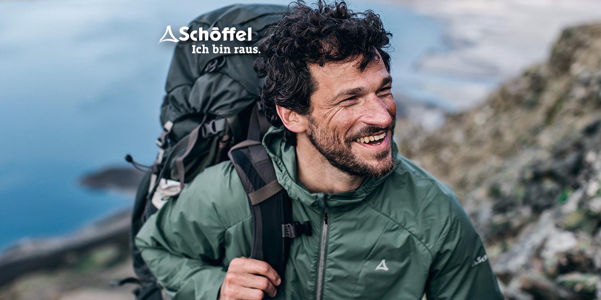 Ein Mann lacht in die Kamera und tr&auml;gt dabei eine gr&uuml;ne Sch&ouml;ffel ZipIn! Jacke