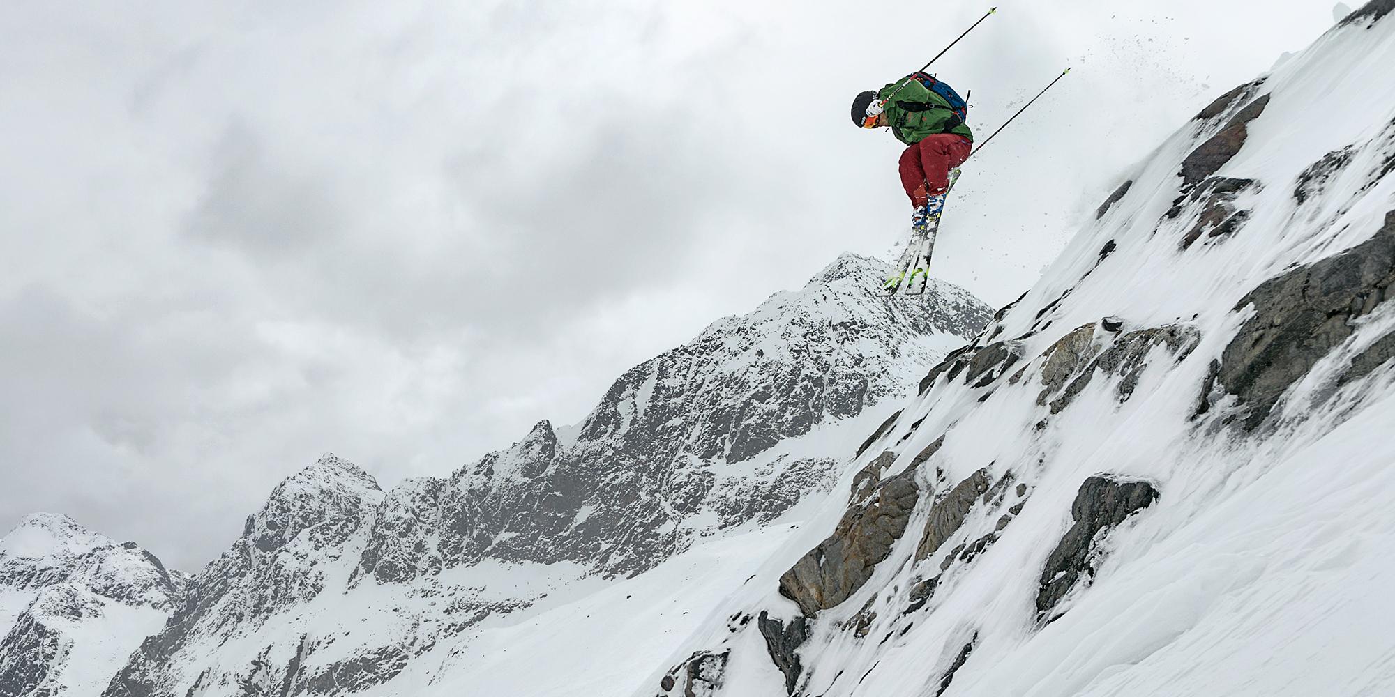 Ein Freeride Skifahrer springt mit seinen Freeride Ski &uuml;ber einen gro&szlig;en Abhang