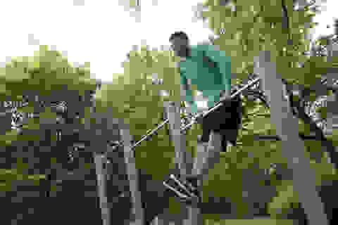 Ein Mann trainiert an einem Klettergerüst in einem Park.