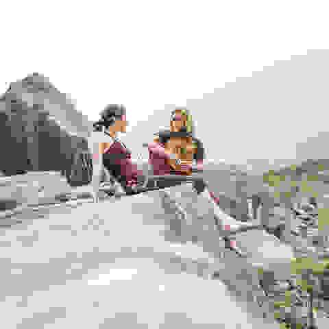 Ein Mann und eine Frau sitzen auf einem Felsen und unterhalten sich.