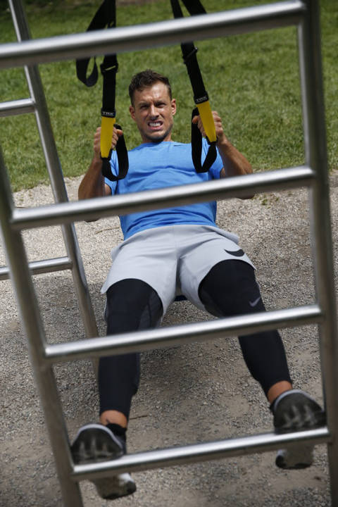 Ein Mann trainiert mit einem Schlingentrainer mit seinem eigenen Körpergewicht.