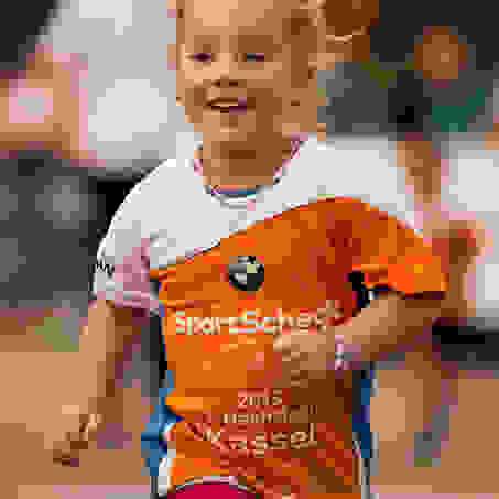 Ein junges Mädchen läuft lächelnd beim Stadtlauf Kassel für Kids mit.