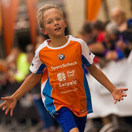 Ein Junge läuft beim Stadtlauf Leipzig ins Ziel ein.