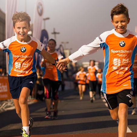 2 Jungs laufen Hand in Hand beim Stadtlauf Nürnberg ins Ziel.