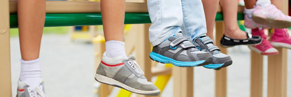 F&uuml;nf Schuhpaare von Kindern, die auf einem Tisch sitzen