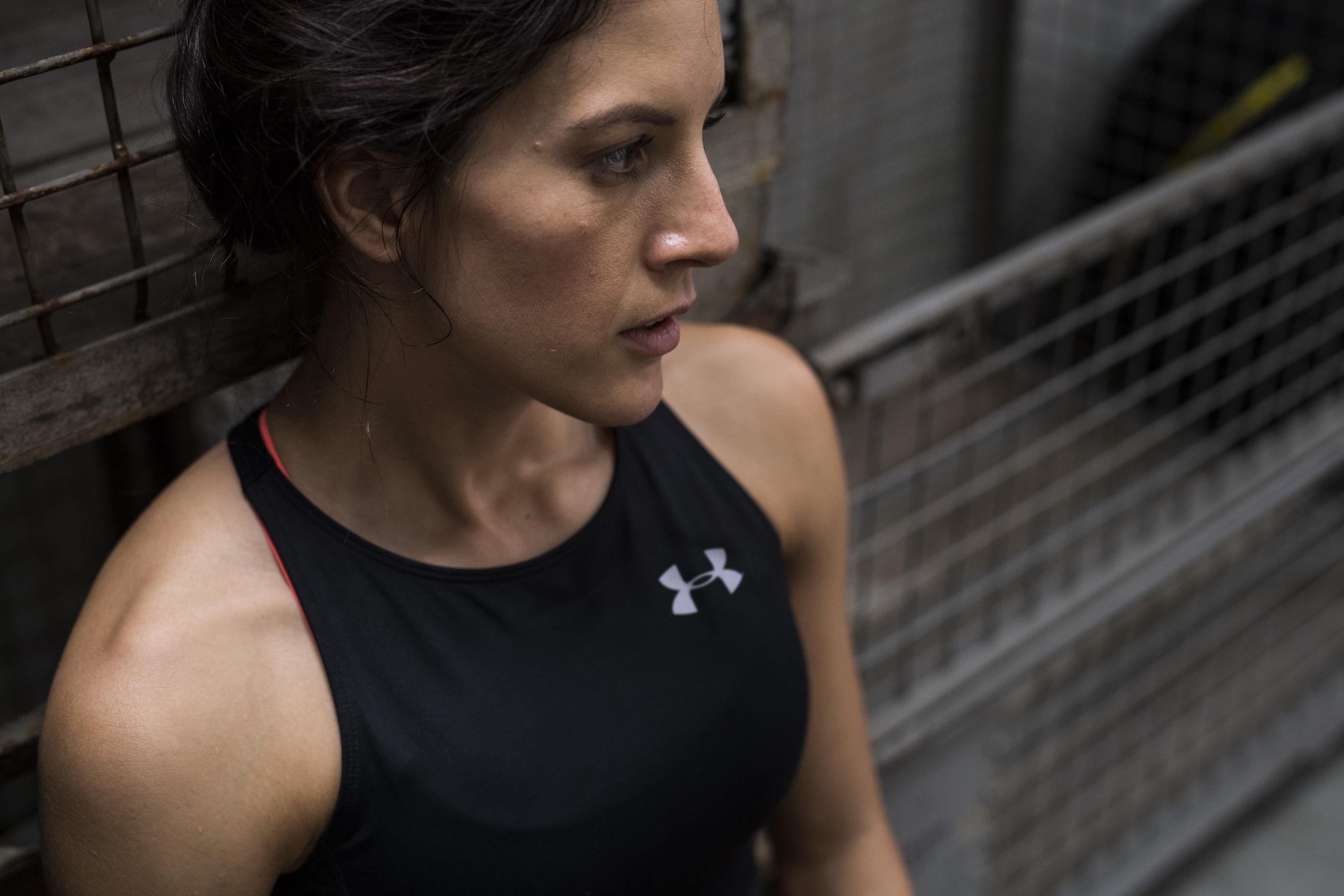 Eine Frau in einem Sporttop lehnt sich an ein Geländer an