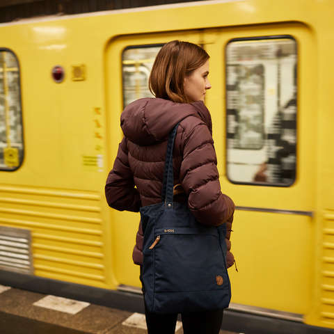 Eine Frau wartet in Berlin auf ihre U-Bahn am Bahnsteig