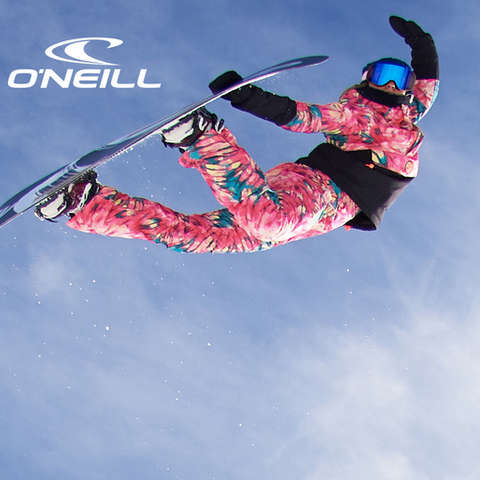 Eine Snowboarderin springt und macht dabei einen Nosegrab