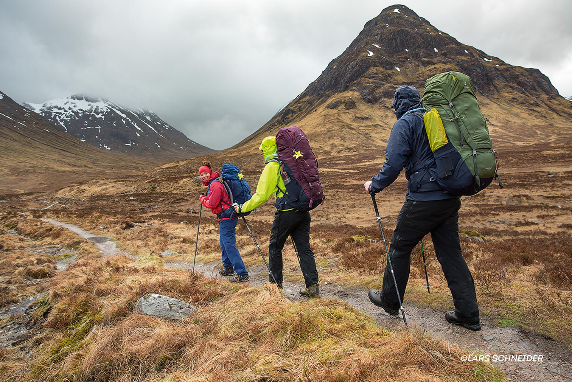 Eine Gruppe Wanderer l&auml;uft durch die schottischen Highlands w&auml;hrend es bew&ouml;lkt ist.
