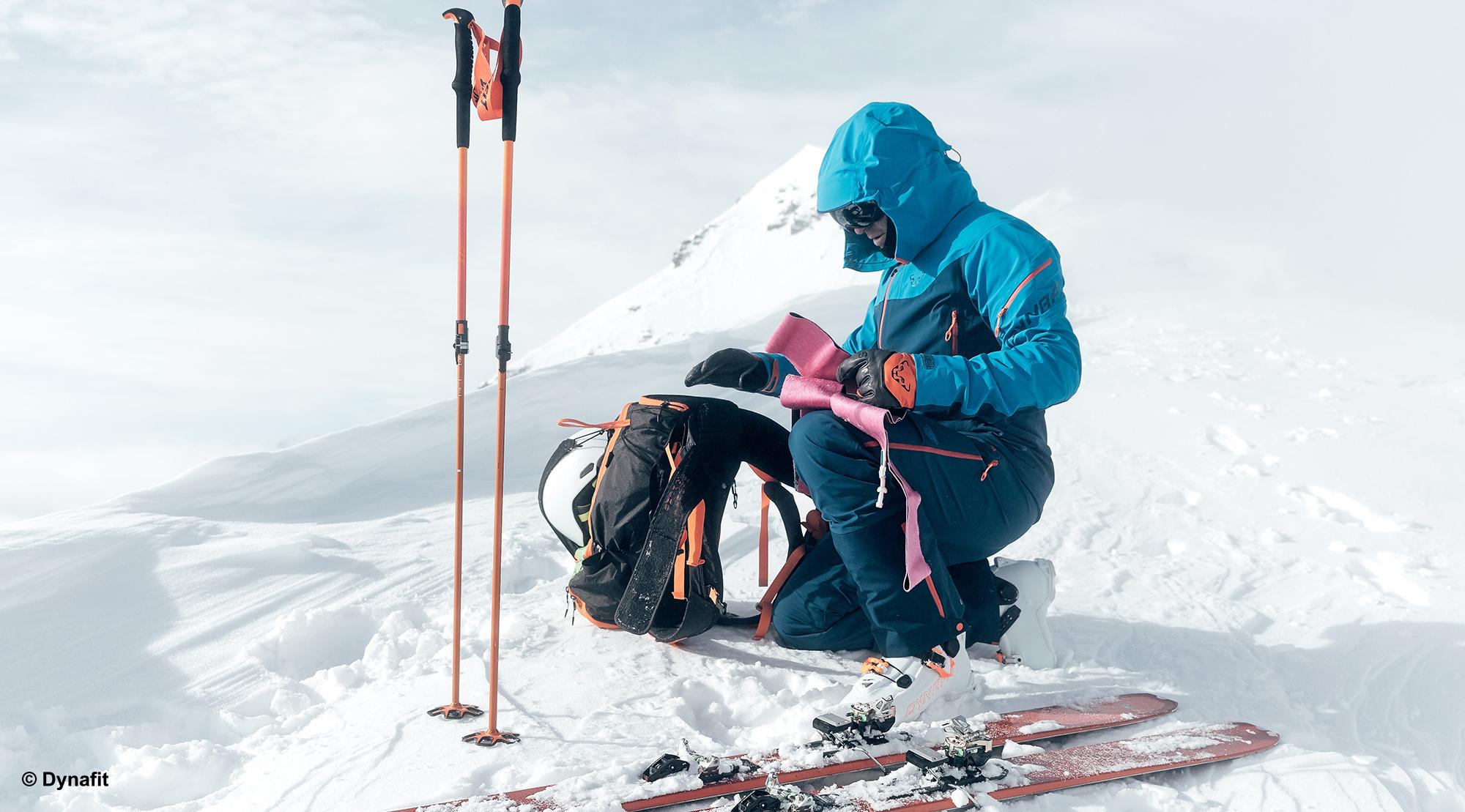 Ein Skitourengeher trägt eine wind und wasserdichte Jacke