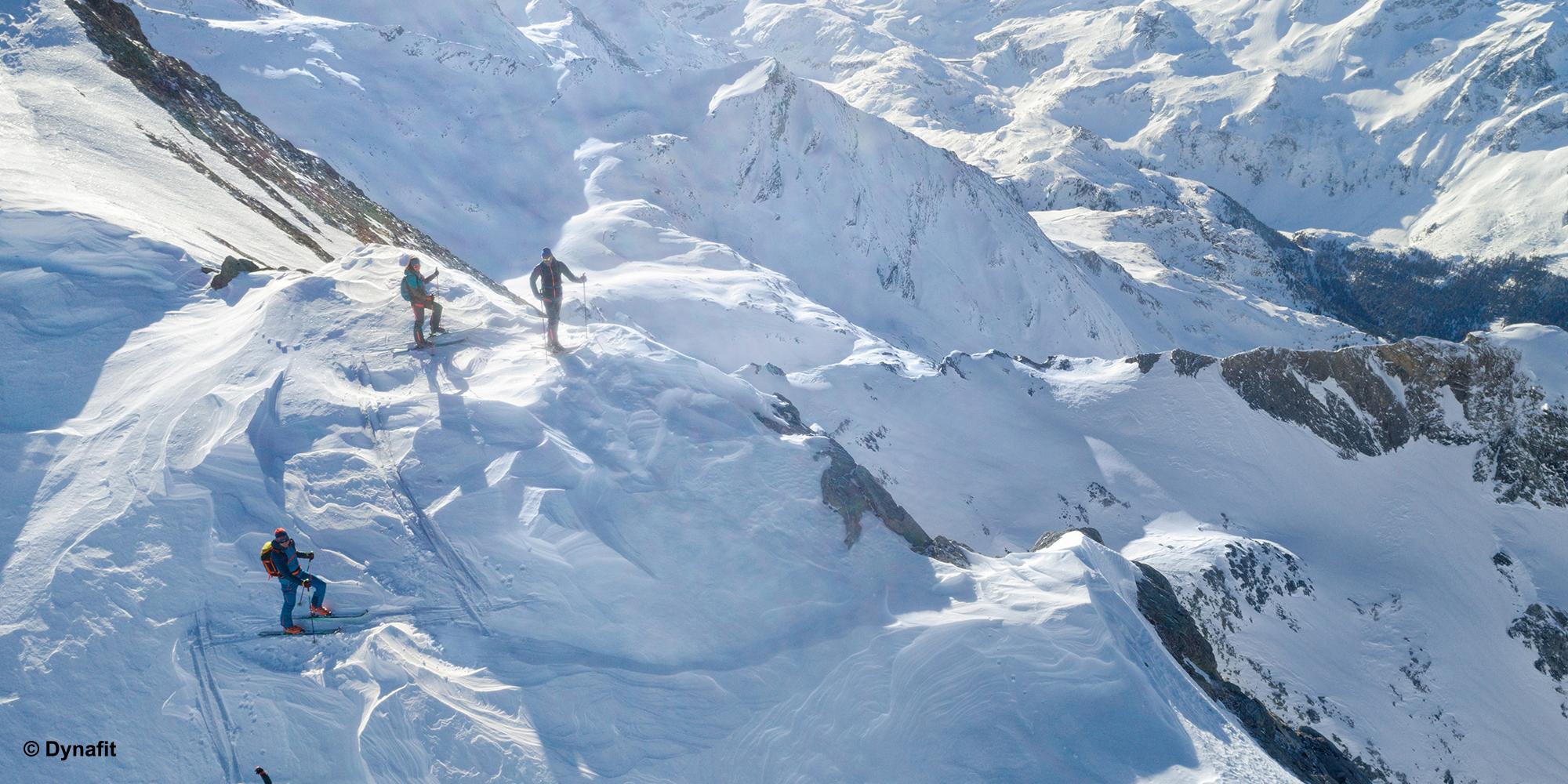 Eine Gruppe Skitourengeher queren eine gef&auml;hrliche Stelle.