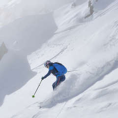 Ein Skitourengeher fährt durch frischen Tiefschnee.
