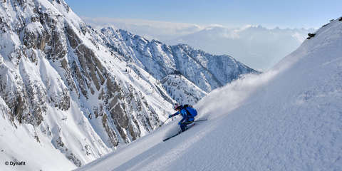 Ein Skitourengeher fährt durch frischen Tiefschnee.