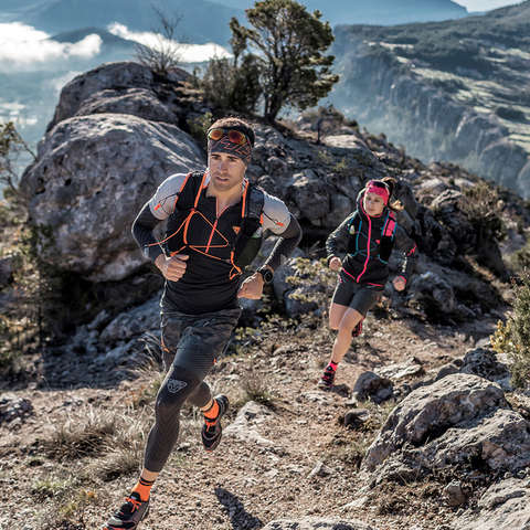 Zwei Trailrunner laufen einen Trail im Hochgebirge.