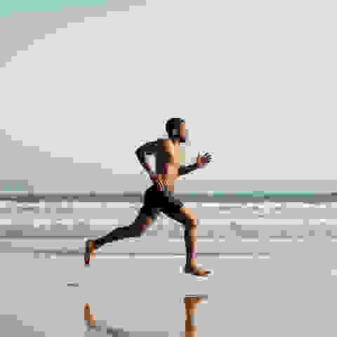 Eine Mann beim Natural Running am Strand.