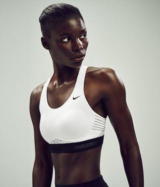 Eine Frau steht mit der Front zur Kamera. Sie trägt einen weißen Nike Pro Fierce Sport BH. Eine Frau steht mit der Front zur Kamera. Sie trägt einen weißen Nike Pro Fierce Sport BH.