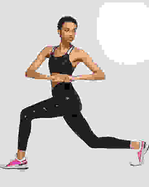 Eine Frau macht einen Ausfallschritt mit der Front zur Kamera. Sie trägt einen schwarzen Nike Alpha Sport-BH mit starkem Halt.