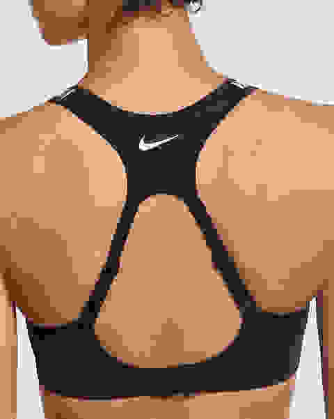 Eine Frau steht mit dem Rücken zur Kamera. Sie trägt einen schwarzen Nike Alpha Sport-BH mit starkem Halt.