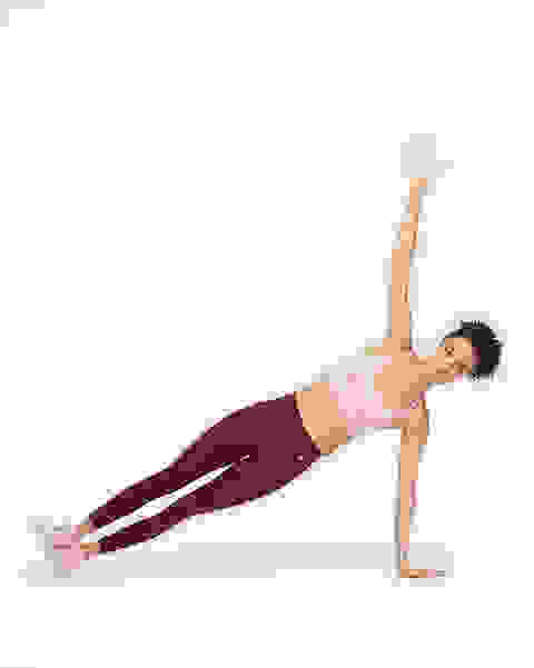 Eine Frau in einem Nike Indy Sport-BH in rosa mit leichtem Halt bei einer Yogaübung.