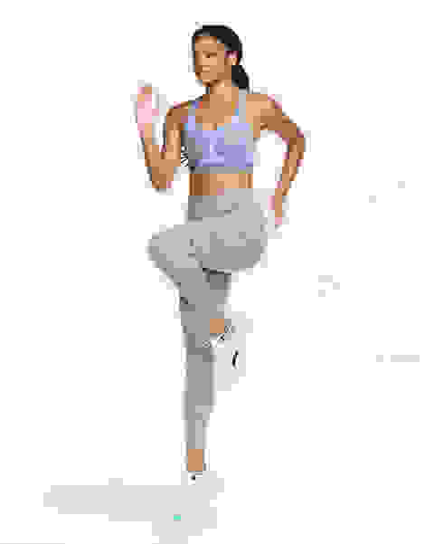 Eine Frau mach Übungen mit der Front zur Kamera. Sie trägt einen blauen Nike Swoosh Ultrabreath Sport BH mit mittlerem Halt.